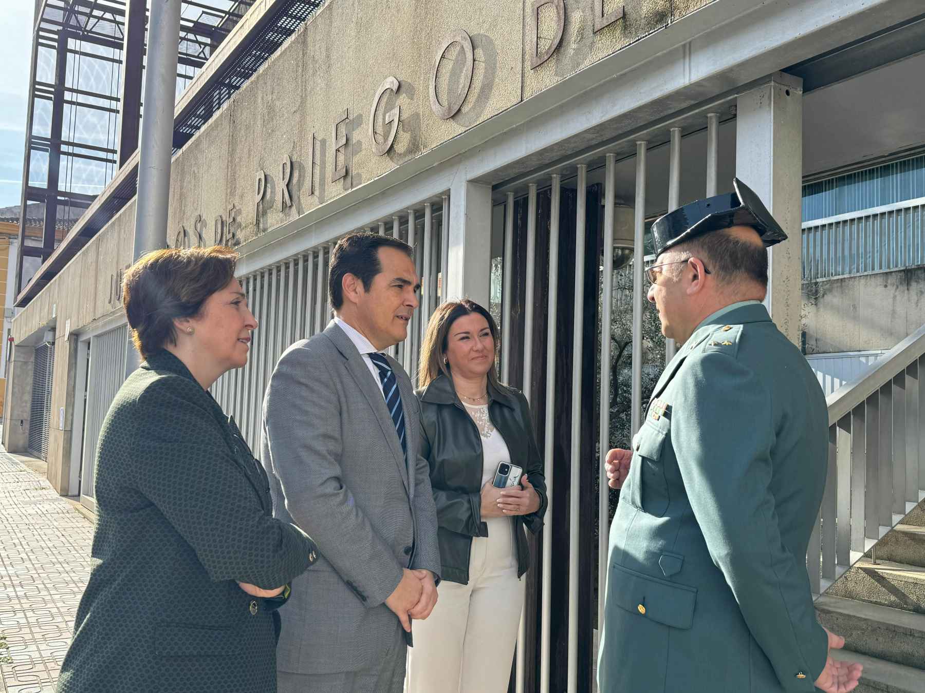 Nieto, junto a Corredera y López, en el acceso a la sede judicial prieguense, saludando al jefe de puesto de la Guardia Civil.