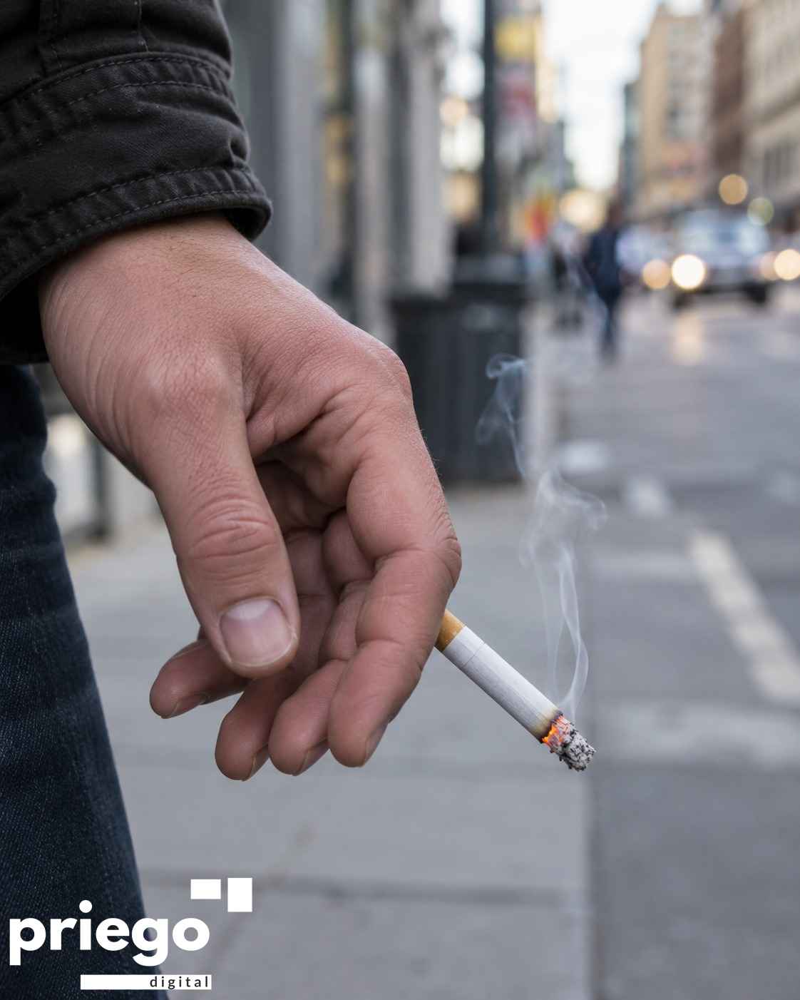 Una persona fuma un cigarrillo en la calle.