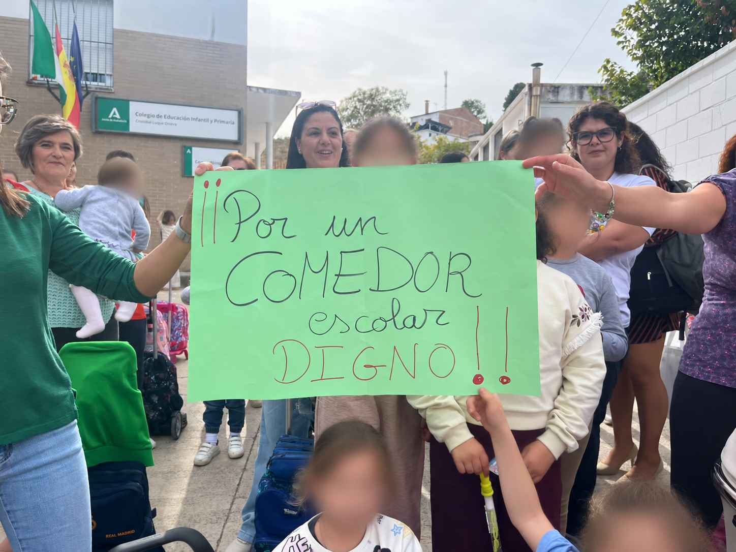 Cartel "Por un comedor escolar digno" en la concentración de las familias.