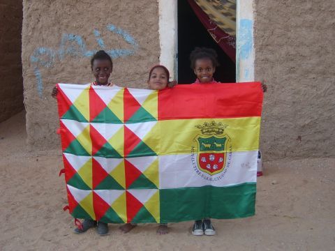 Niños saharauis con la bandera de Cabra en los campamentos de refugiados en Argelia. (Foto: AMANS)