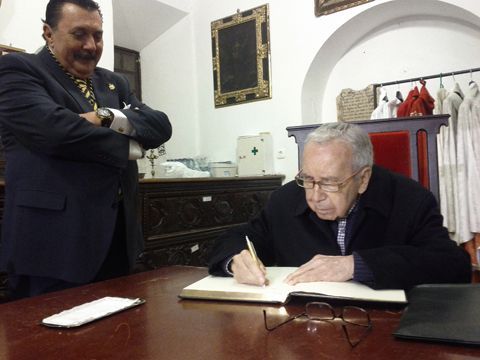 García Bena firmando en el libro de la cofradía de la Soledad, en presencia de su hermano mayor, Juan Manuel de los Ríos. (Foto: Cedida)